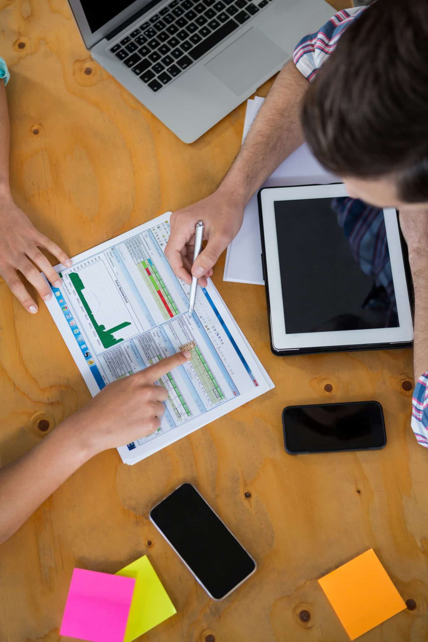 Business executives discussing charts and graphs on desk